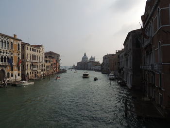 Canal amidst buildings against sky