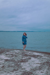 Young girl on a background of the sea in a blue dress, portrait