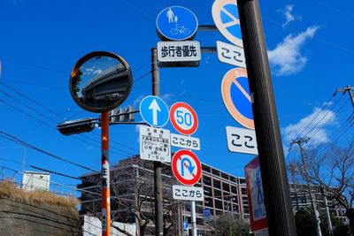 Low angle view of road sign against blue sky