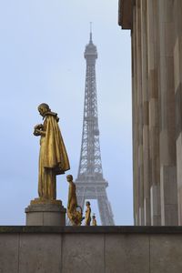 Statue of tower in city against sky