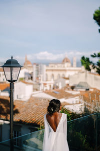 Rear view of bride looking at townscape