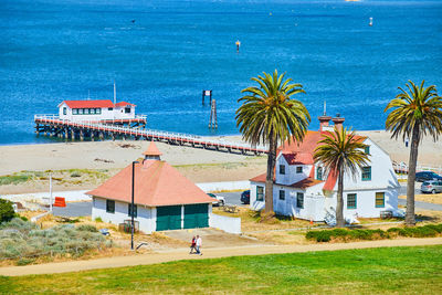 Houses by sea against sky