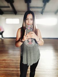 Full length portrait of a beautiful young woman drinking