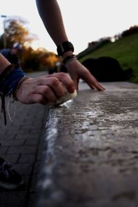 Close-up of person rubbing wax on retaining wall