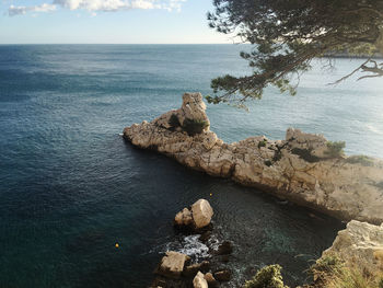 High angle view of rock formation in sea against sky