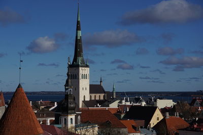 Buildings in city against cloudy sky