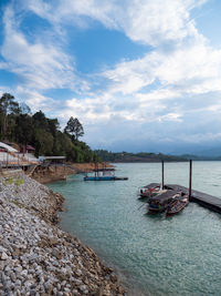 Boats moored in sea against sky