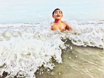 Boy in the sea against sky