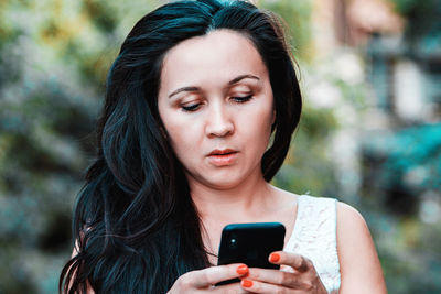 Young woman using mobile phone outdoors