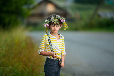 Portrait of cute girl wearing flower while standing outdoors