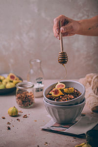 Midsection of person preparing food in bowl on table