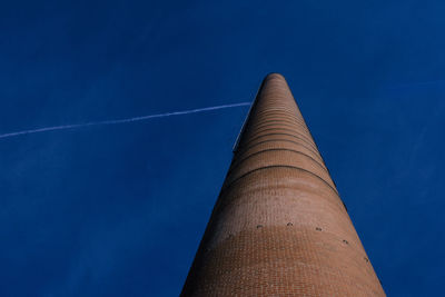 Low angle view of chimney against blue sky