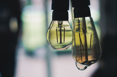 Close-up of light bulb hanging on glass