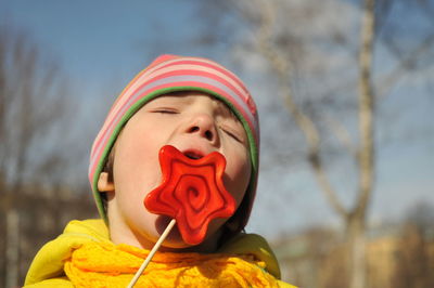 Close-up of boy eating lollipop during sunny day