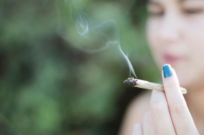 Close-up of woman smoking marijuana joint