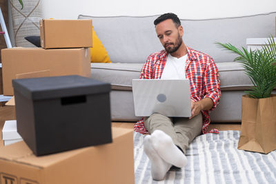 Portrait of young man using digital tablet while sitting on sofa at home