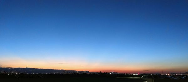 Scenic view of landscape against clear sky at sunset