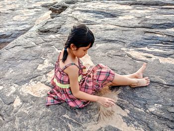 High angle view of woman sitting on rock