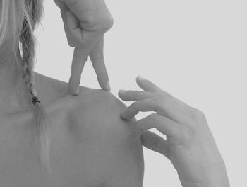 Cropped image of woman standing against white wall