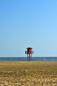 Lifeguard hut on beach against clear sky