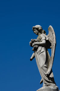 Low angle view of statue against clear blue sky