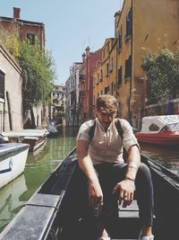 Full length of man sitting in city against sky