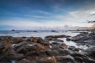 Scenic view of rocks on beach against sky