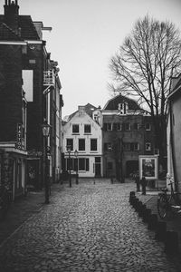 Street amidst houses and buildings against sky
