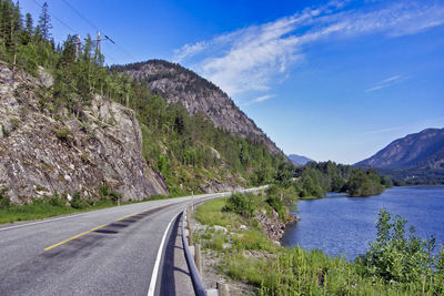 Road by mountains against sky