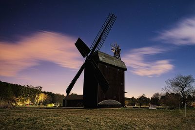 Traditional windmill on field against sky