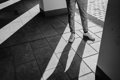 Low section of person standing on tiled floor