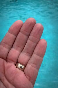 Close-up of human hand holding swimming pool