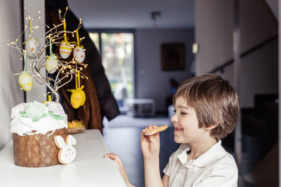 Portrait of young woman holding christmas tree at home