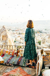 Woman at sunrise with hot air balloons rising up in cappadocia turkey