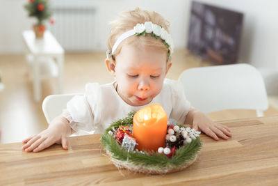 Deaf girl looking at tealight candle on table