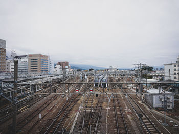 High angle view of railroad tracks amidst buildings against sky