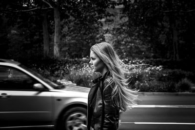 Profile view of young woman standing on road