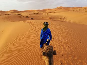 Rear view of man riding in desert