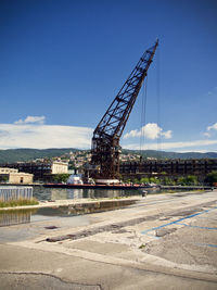 Cranes at construction site against sky