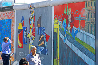 Portrait of friends standing on multi colored wall