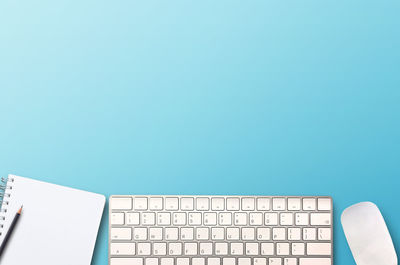 Close-up of computer keyboard against blue background