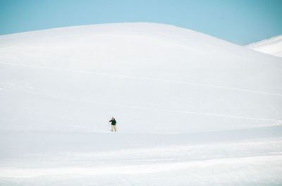 Person on snowcapped mountain against sky