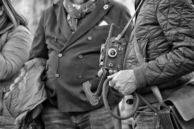  people standing on street with old analogue camera