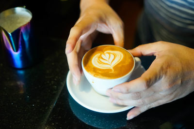 Midsection of man holding coffee cup