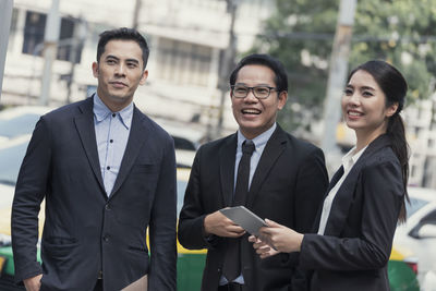 Business people discussing while standing in front of office