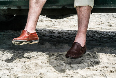 Low section of man standing on beach