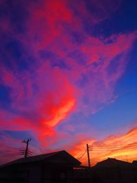 Low angle view of silhouette houses against sky during sunset