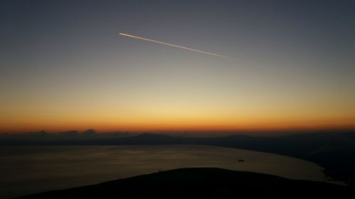 Scenic view of silhouette mountains against clear sky during sunset