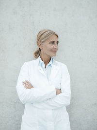 Biologist with arms crossed in front of wall