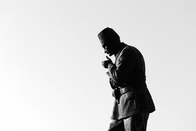 Side view of man standing against white background